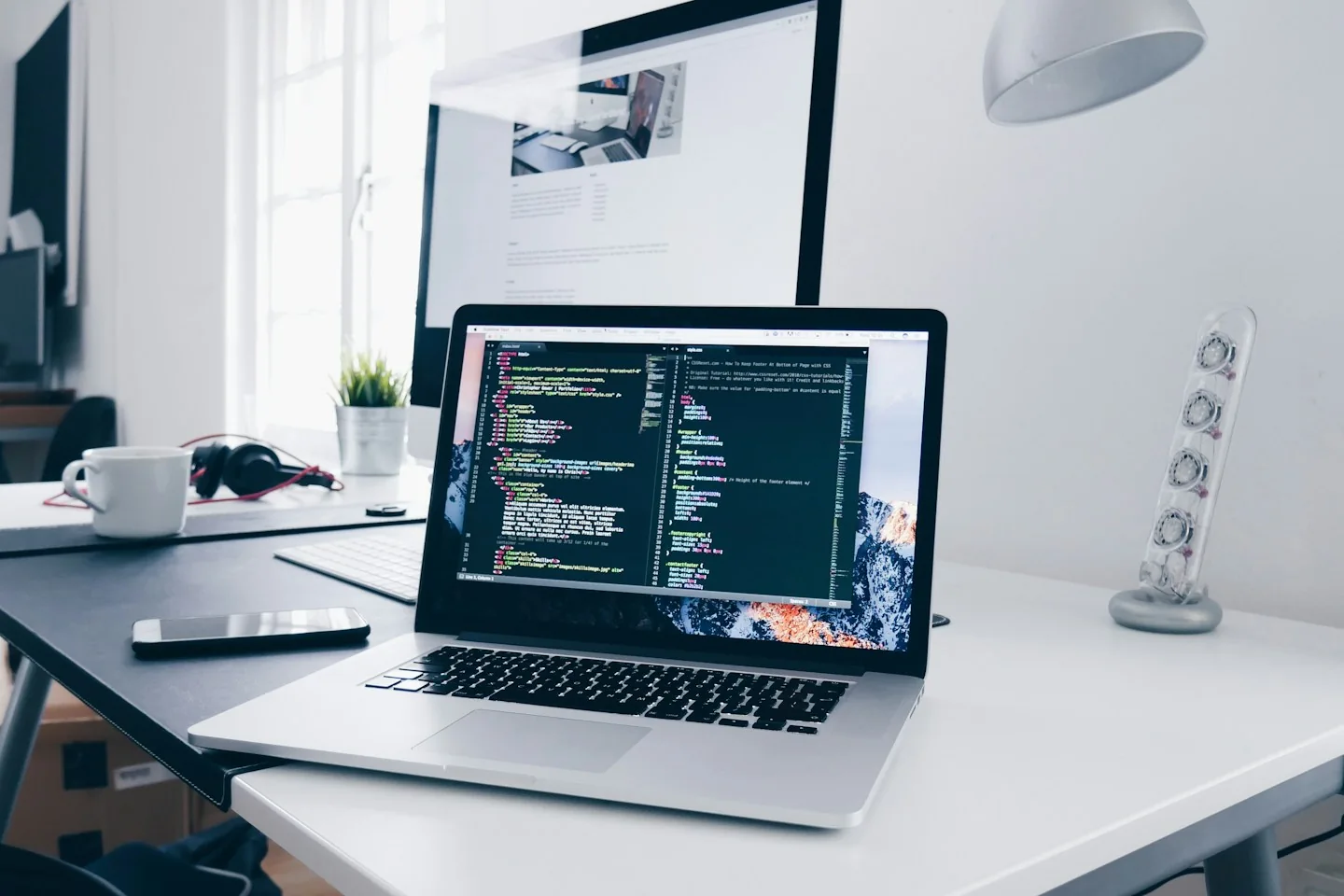 Ordinateur portable et écran de code sur un bureau lumineux.